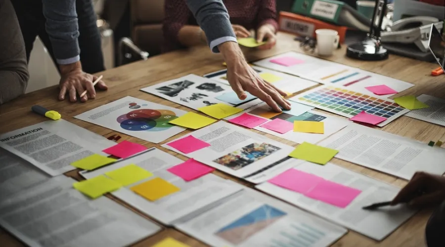 tafel met verschillende plannen en post its erop geplakt