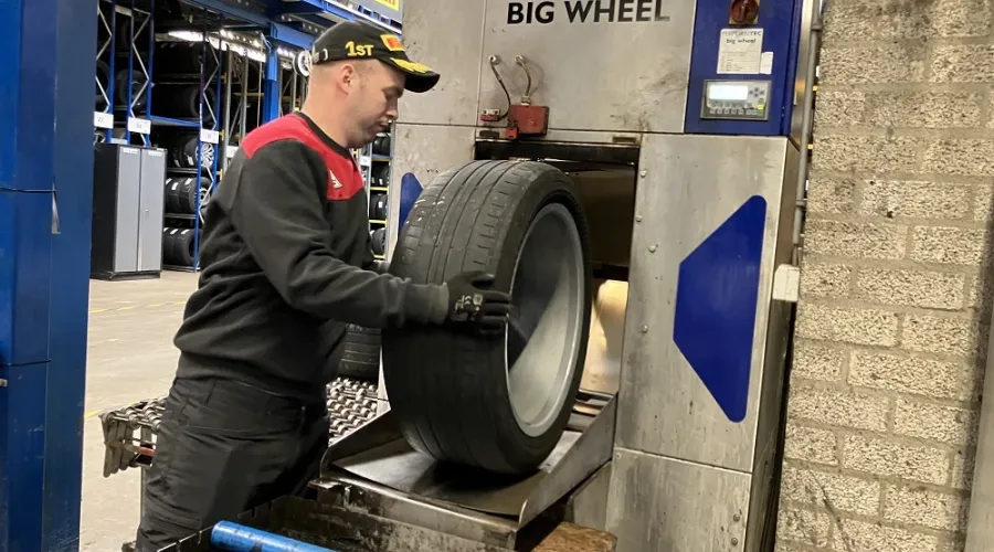 Jongen is aan het werk met een autoband in een apparaat