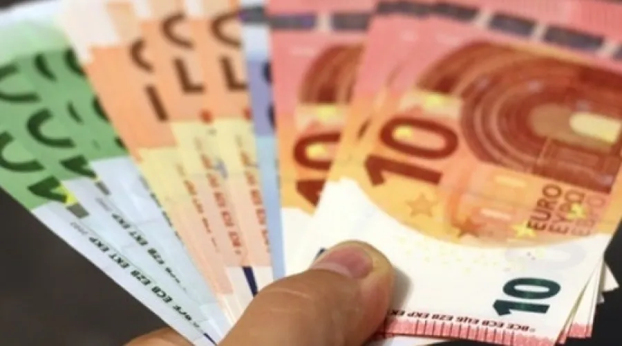 Hand houdt een stapeltje euro's vast